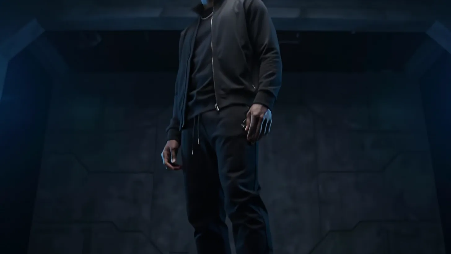 A man in black stepping out of shadow in cobalt high-tops