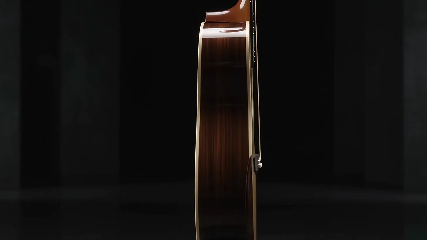 The finished guitar seen edge-on, rosewood sides catching a line of light